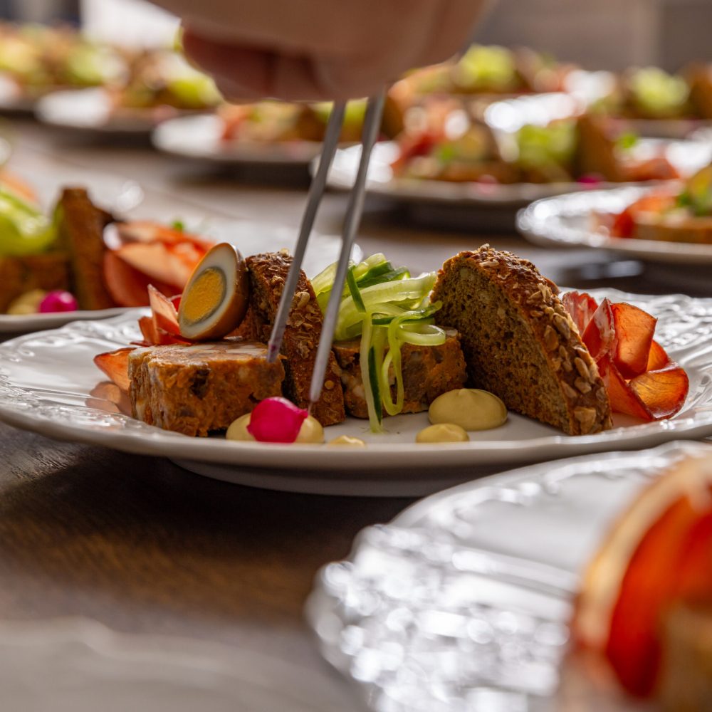 Chef are arranging small pieces of food with precision, showcasing their culinary skills.