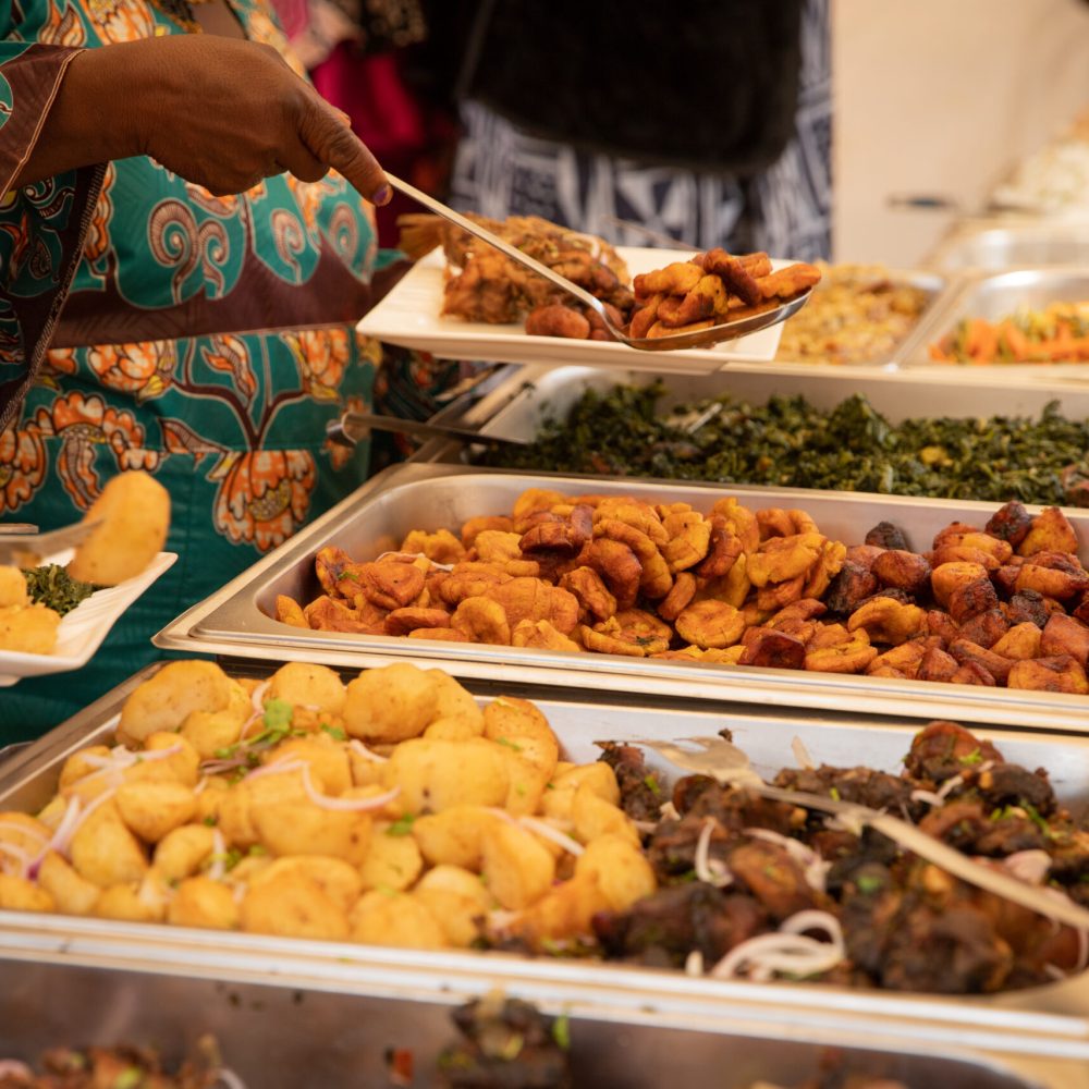 close-up of African food during a buffet at a party. Fried plantains, potatoes, meat and vegetables